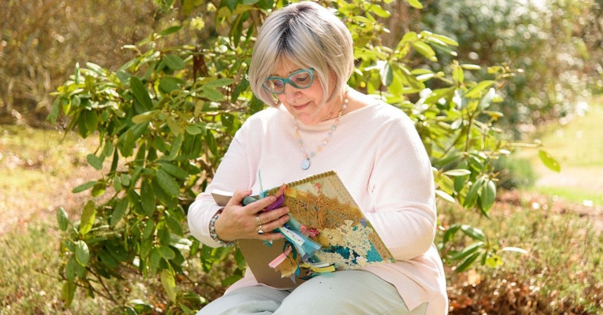 April Goff Brown sitting down, reflecting and writing down her thoughts within her journal.