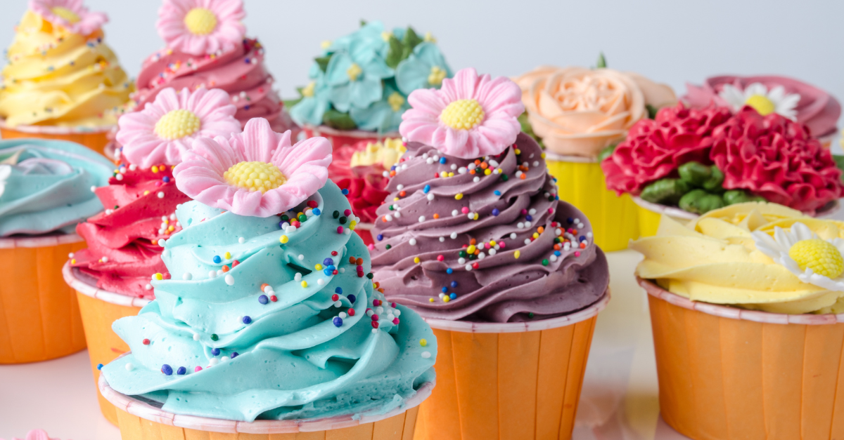 Colorful springtime cupcakes sit on a tabletop.