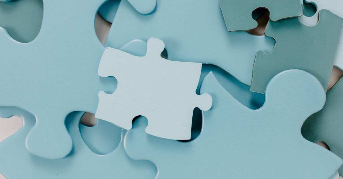 Aqua and turquoise puzzle pieces laying on a table.