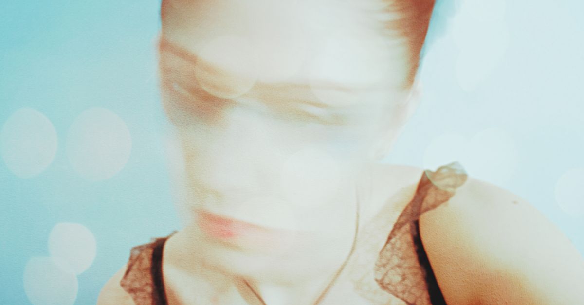 Blurry portrait of a woman with soft light effects, symbolizing confusion and self-sabotage patterns that cloud clarity and personal growth.